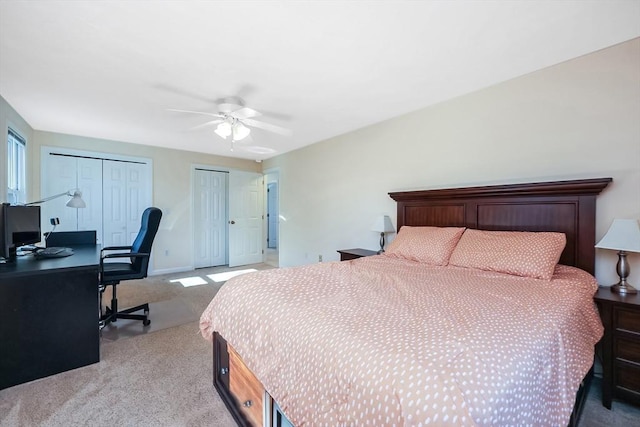 carpeted bedroom featuring multiple closets and ceiling fan