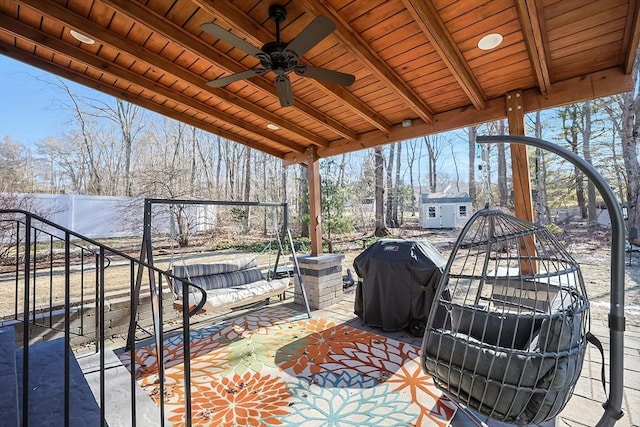 view of patio with ceiling fan, area for grilling, and a shed