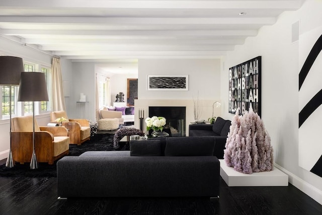 living area with beamed ceiling, a fireplace, wood finished floors, and baseboards