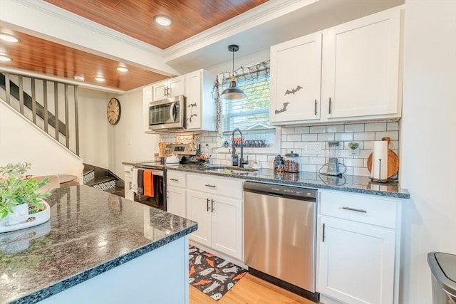 kitchen featuring hanging light fixtures, white cabinets, appliances with stainless steel finishes, wooden ceiling, and sink