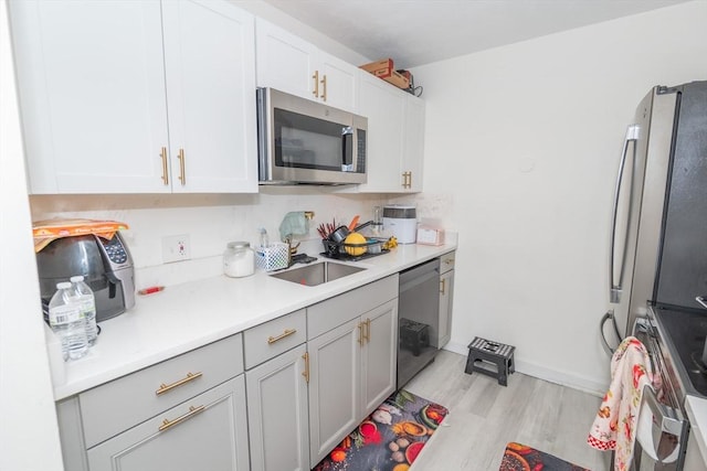 170 Highland St Unit 119D, Taunton, MA 02780 - kitchen with stainless steel appliances, a sink, light wood-style floors, light countertops, and white cabinetry