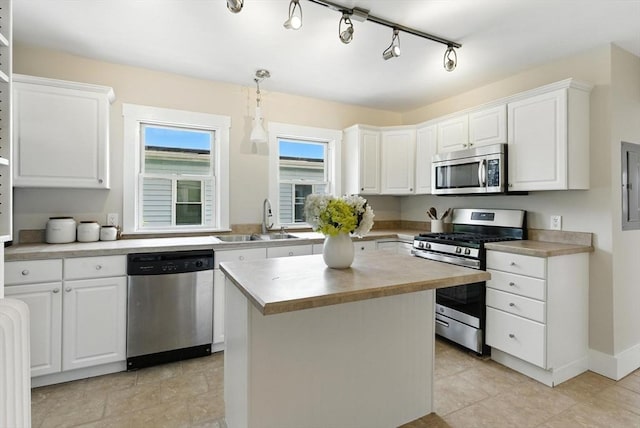216 Cedar St Unit 3, Somerville, MA 02144 - kitchen featuring stainless steel appliances, white cabinets, a kitchen island, and decorative light fixtures