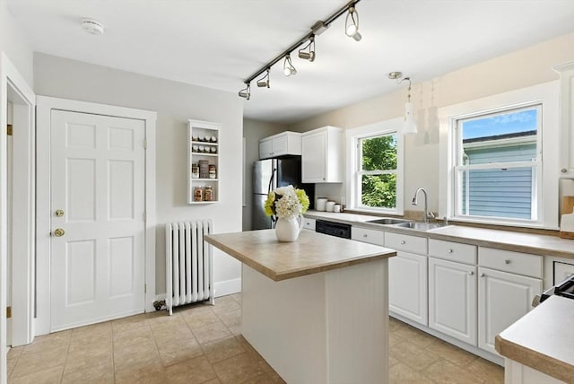 216 Cedar St Unit 3, Somerville, MA 02144 - kitchen with radiator heating unit, freestanding refrigerator, white cabinets, and light countertops