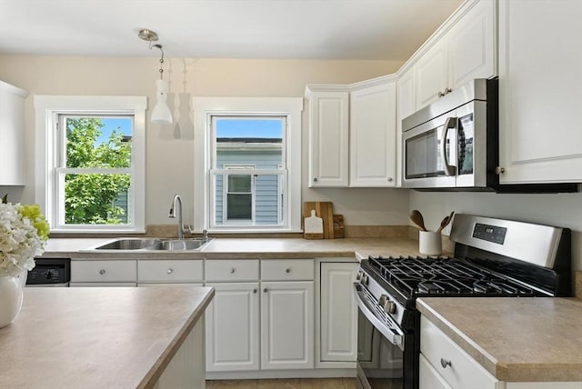 216 Cedar St Unit 3, Somerville, MA 02144 - kitchen featuring stainless steel appliances, white cabinetry, light countertops, and decorative light fixtures