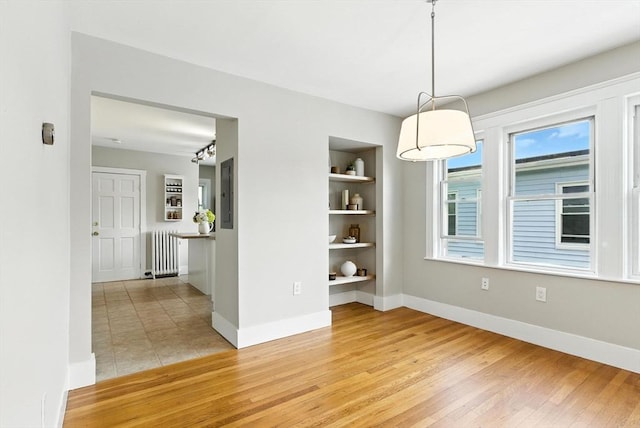 216 Cedar St Unit 3, Somerville, MA 02144 - unfurnished dining area featuring radiator heating unit, light wood-style flooring, and healthy amount of natural light