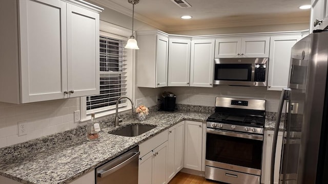 kitchen with white cabinets, decorative backsplash, stainless steel appliances, and a sink