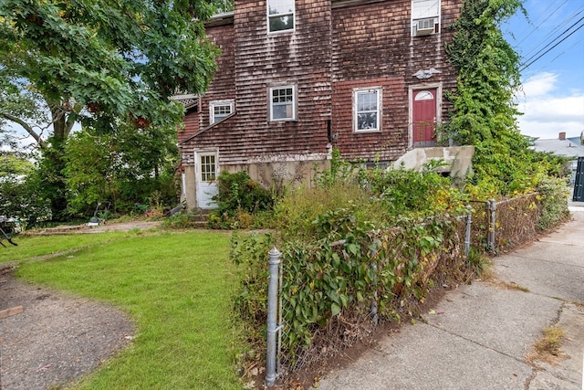 view of side of property featuring cooling unit and a lawn