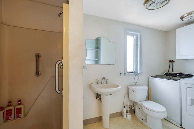 bathroom featuring toilet and washing machine and clothes dryer