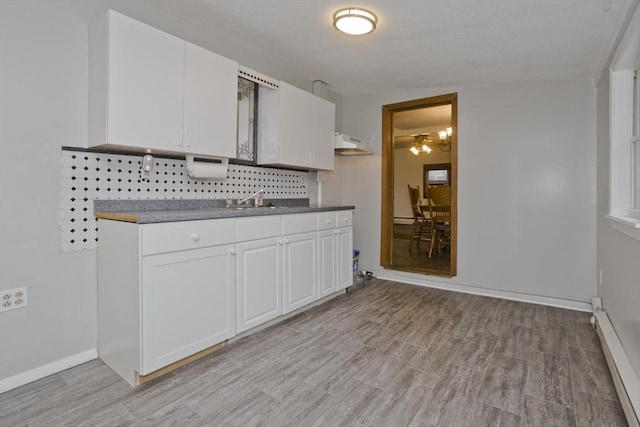 12 Allen St, Chicopee, MA 01020 - kitchen with baseboard heating, backsplash, light wood-type flooring, and white cabinets