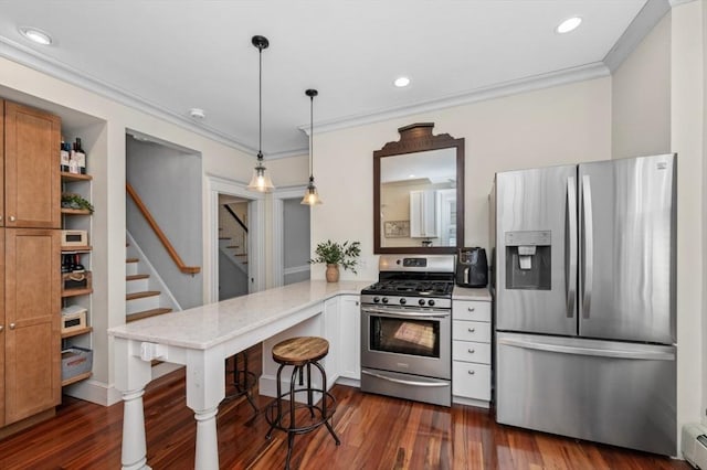 kitchen with appliances with stainless steel finishes, a peninsula, dark wood finished floors, ornamental molding, and light stone countertops