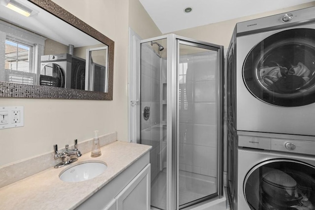 bathroom featuring estacked washer and dryer, a stall shower, and vanity