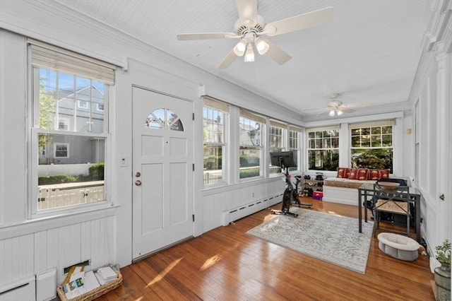 sunroom with a baseboard radiator, wood finished floors, a baseboard heating unit, and ornamental molding