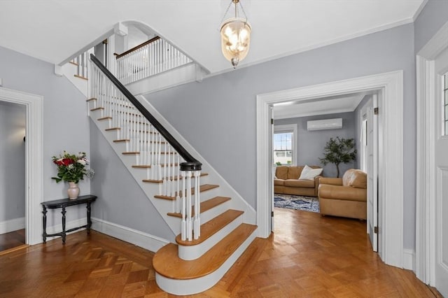 stairway featuring a wall mounted AC, baseboards, and crown molding