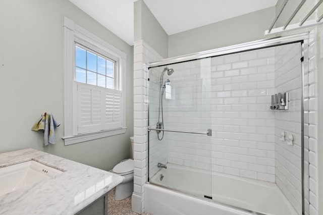 bathroom with enclosed tub / shower combo, toilet, and a sink