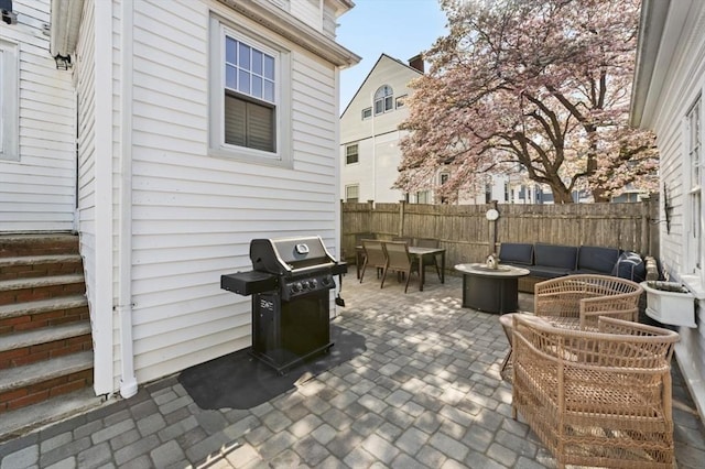 view of patio with outdoor dining space, grilling area, fence, and an outdoor hangout area