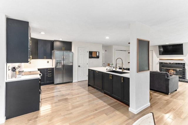 11 Running Stream Rd, Rehoboth, MA 02769 - kitchen with stainless steel fridge with ice dispenser, light countertops, dark cabinetry, light wood-type flooring, and decorative backsplash