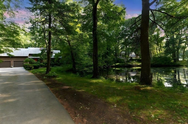 11 Running Stream Rd, Rehoboth, MA 02769 - yard at dusk featuring a water view, driveway, and a garage