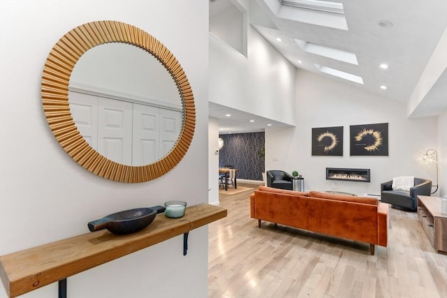 11 Running Stream Rd, Rehoboth, MA 02769 - living room with a skylight, light wood-style flooring, high vaulted ceiling, recessed lighting, and a glass covered fireplace