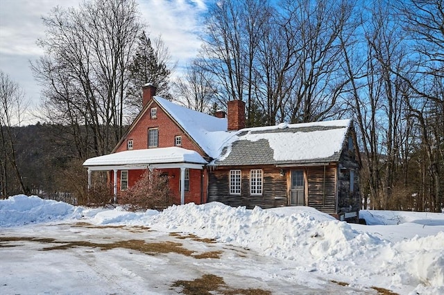 exterior space with brick siding and a chimney