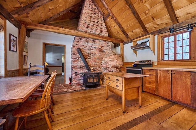 kitchen with stainless steel electric range, light countertops, wooden ceiling, and a wood stove