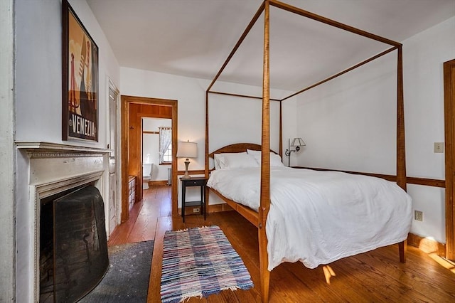 bedroom featuring hardwood / wood-style flooring and a fireplace