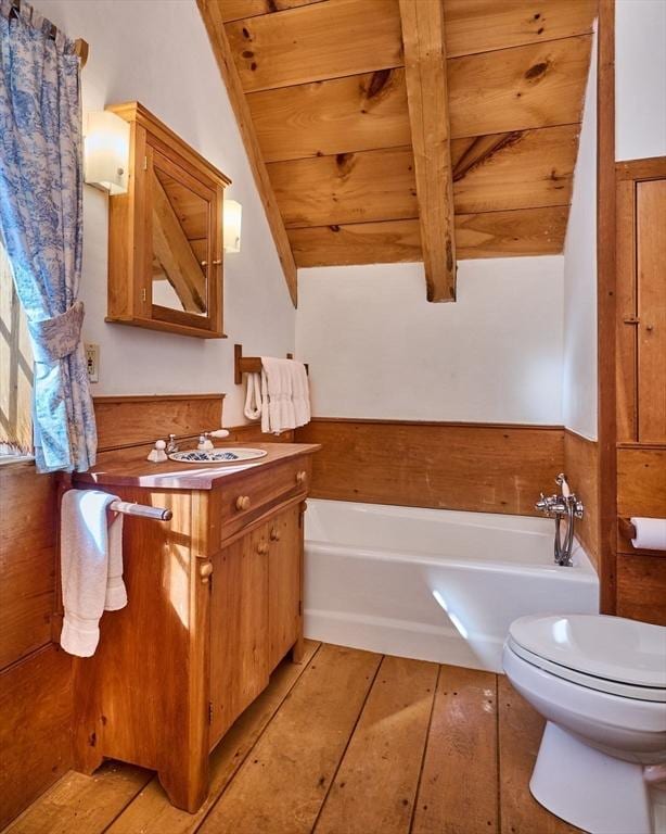 bathroom with a garden tub, toilet, lofted ceiling with beams, wooden ceiling, and vanity