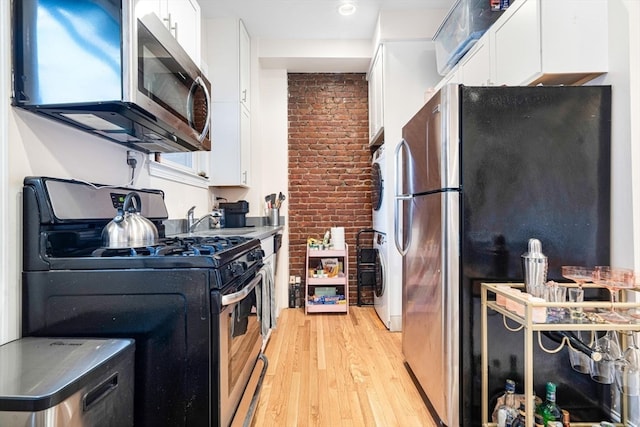 kitchen featuring white cabinetry, light wood-type flooring, sink, and stainless steel appliances