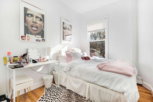 bedroom featuring hardwood / wood-style floors and a baseboard radiator