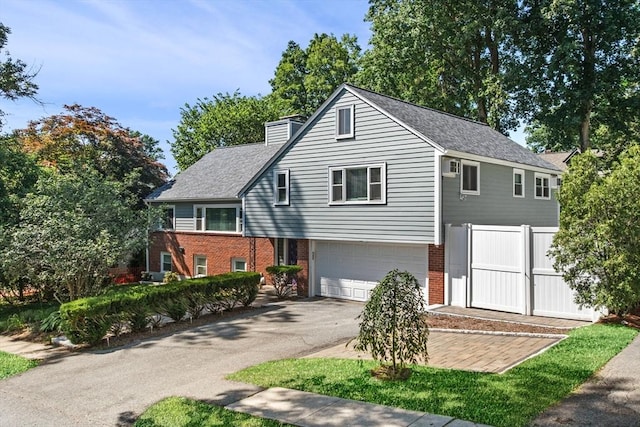 4 Chestnut St, Winchester, MA 01890 - view of front of house featuring asphalt driveway, brick siding, an attached garage, a chimney, and roof with shingles