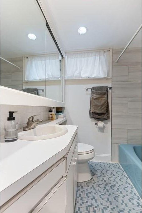 full bath featuring tasteful backsplash, vanity, toilet, recessed lighting, and tub / shower combination