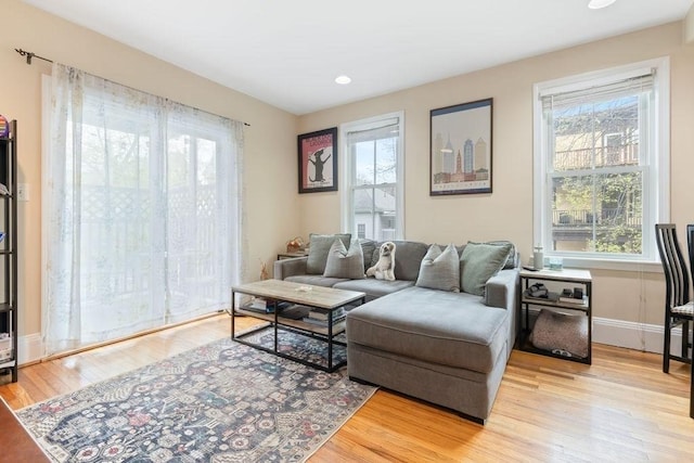 living area with baseboards, recessed lighting, light wood-style flooring, and a wealth of natural light
