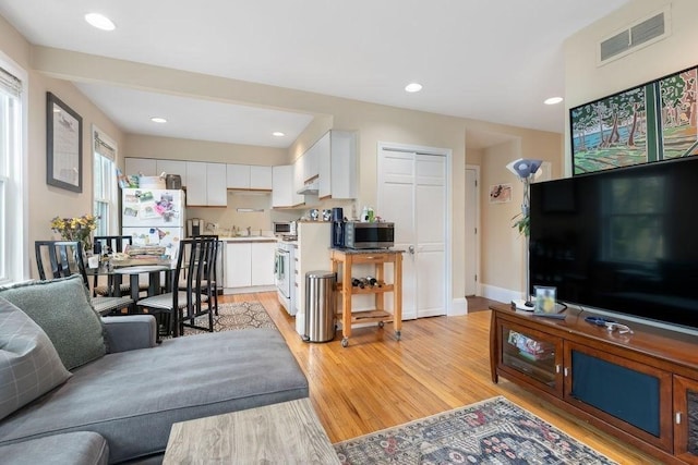 living room featuring visible vents, recessed lighting, light wood finished floors, and baseboards