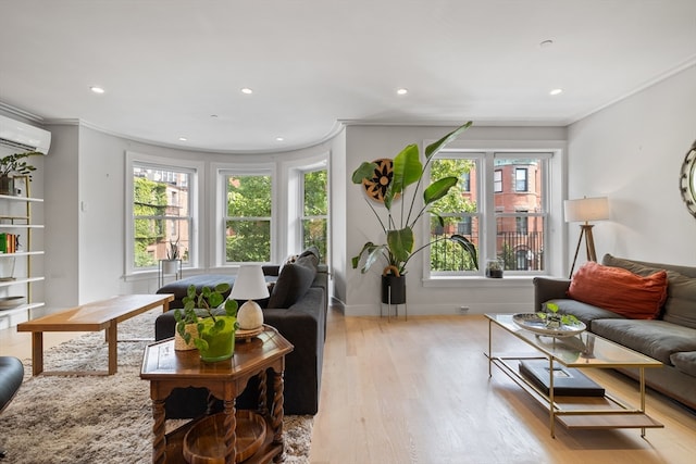 living room with light wood-type flooring, crown molding, and an AC wall unit