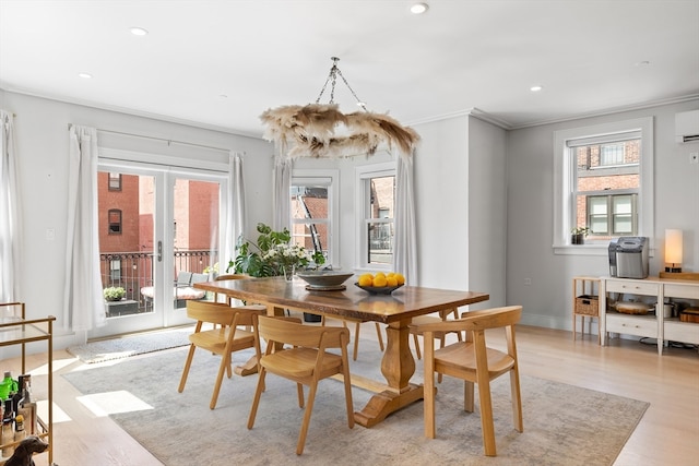 dining area with ornamental molding, french doors, a wall unit AC, and light hardwood / wood-style floors