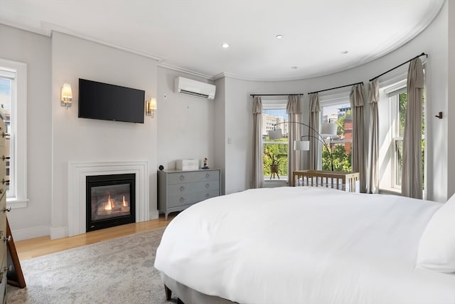 bedroom with light hardwood / wood-style flooring and a wall unit AC