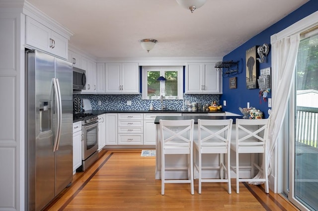 29 Wituwamat Rd, Weymouth, MA 02191 - kitchen with stainless steel appliances, dark countertops, a sink, tasteful backsplash, and white cabinets