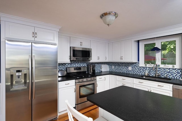 29 Wituwamat Rd, Weymouth, MA 02191 - kitchen featuring appliances with stainless steel finishes, a sink, dark countertops, tasteful backsplash, and white cabinets