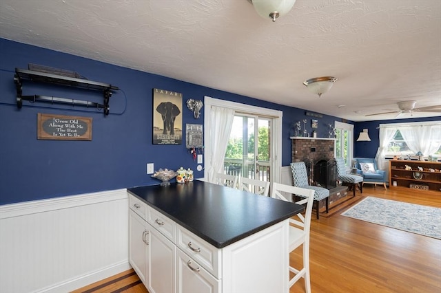 29 Wituwamat Rd, Weymouth, MA 02191 - kitchen featuring healthy amount of natural light, light wood-style floors, a peninsula, wainscoting, and dark countertops