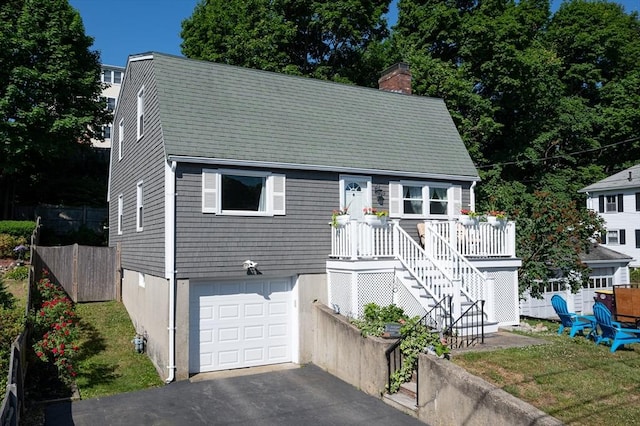 29 Wituwamat Rd, Weymouth, MA 02191 - view of front facade with a chimney, a garage, and asphalt driveway
