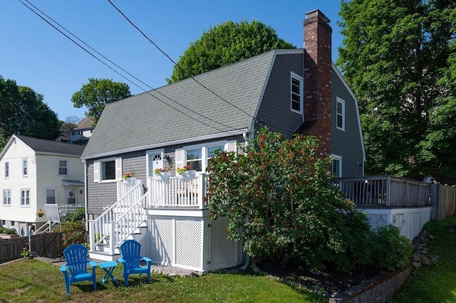 29 Wituwamat Rd, Weymouth, MA 02191 - back of property with a deck, a chimney, stairway, and a gambrel roof