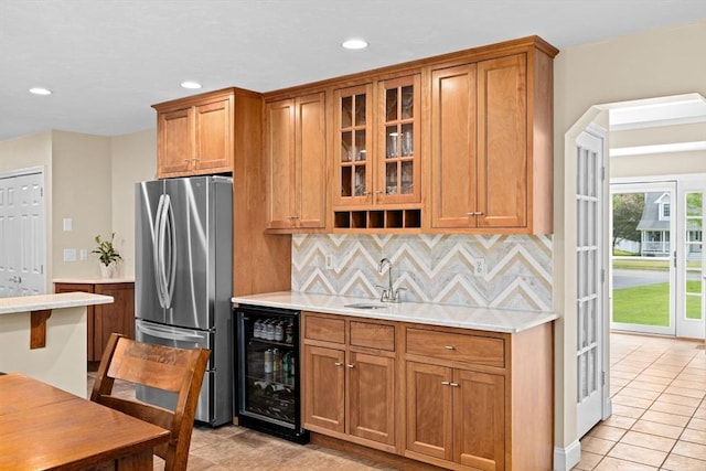 102 Saddleworth Way, Middleboro, MA 02346 - kitchen with freestanding refrigerator, beverage cooler, light tile patterned floors, light countertops, and brown cabinets