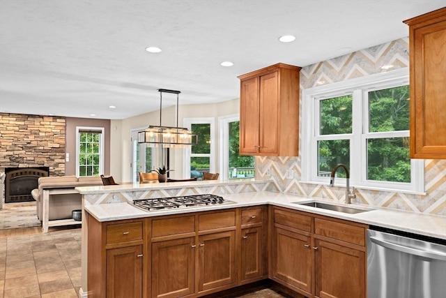 102 Saddleworth Way, Middleboro, MA 02346 - kitchen featuring appliances with stainless steel finishes, a peninsula, light countertops, brown cabinetry, and decorative backsplash