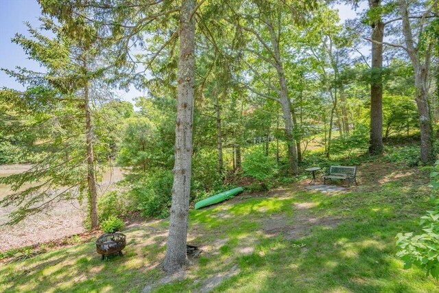 22 Wallace Pt, Bourne, MA 02532 - view of yard featuring an outdoor fire pit and a wooded view