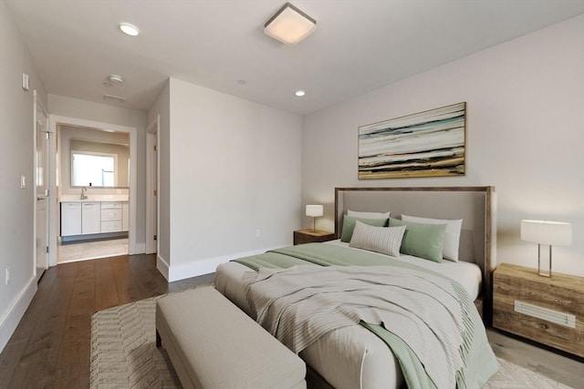 bedroom with recessed lighting, ensuite bathroom, a sink, wood finished floors, and baseboards