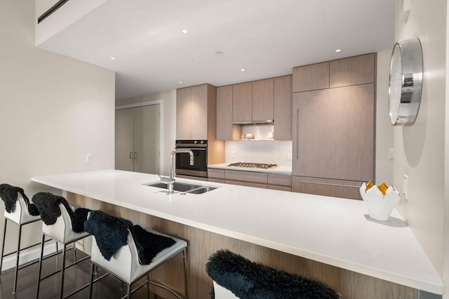 43 Westland Ave Unit 512, Boston, MA 02115 - kitchen featuring stainless steel gas stovetop, decorative backsplash, a peninsula, oven, and a sink
