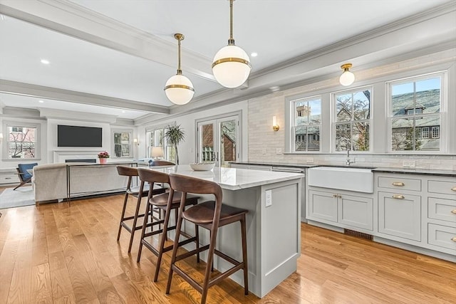 4 Norwood St, Winchester, MA 01890 - kitchen with crown molding, tasteful backsplash, light stone counters, a kitchen breakfast bar, and plenty of natural light