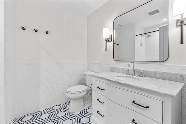 4 Norwood St, Winchester, MA 01890 - full bath featuring vanity, wainscoting, tile walls, and tile patterned flooring
