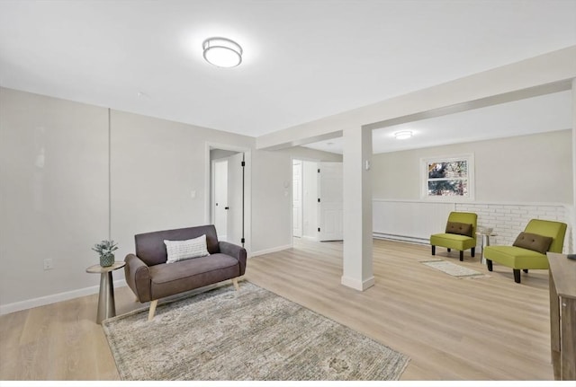 sitting room with baseboards, light wood-style floors, and baseboard heating