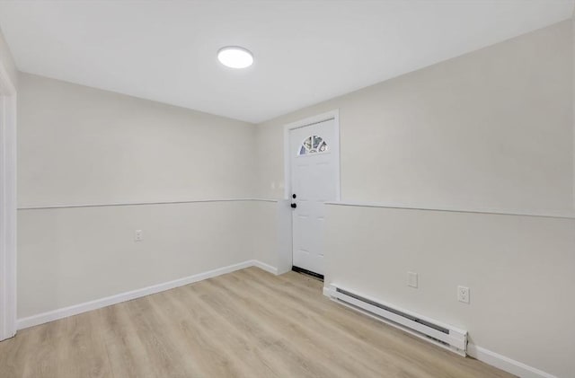 unfurnished room with light wood-type flooring, a baseboard radiator, and baseboards