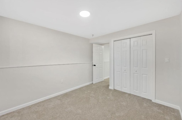 unfurnished bedroom featuring carpet flooring, baseboards, and a closet